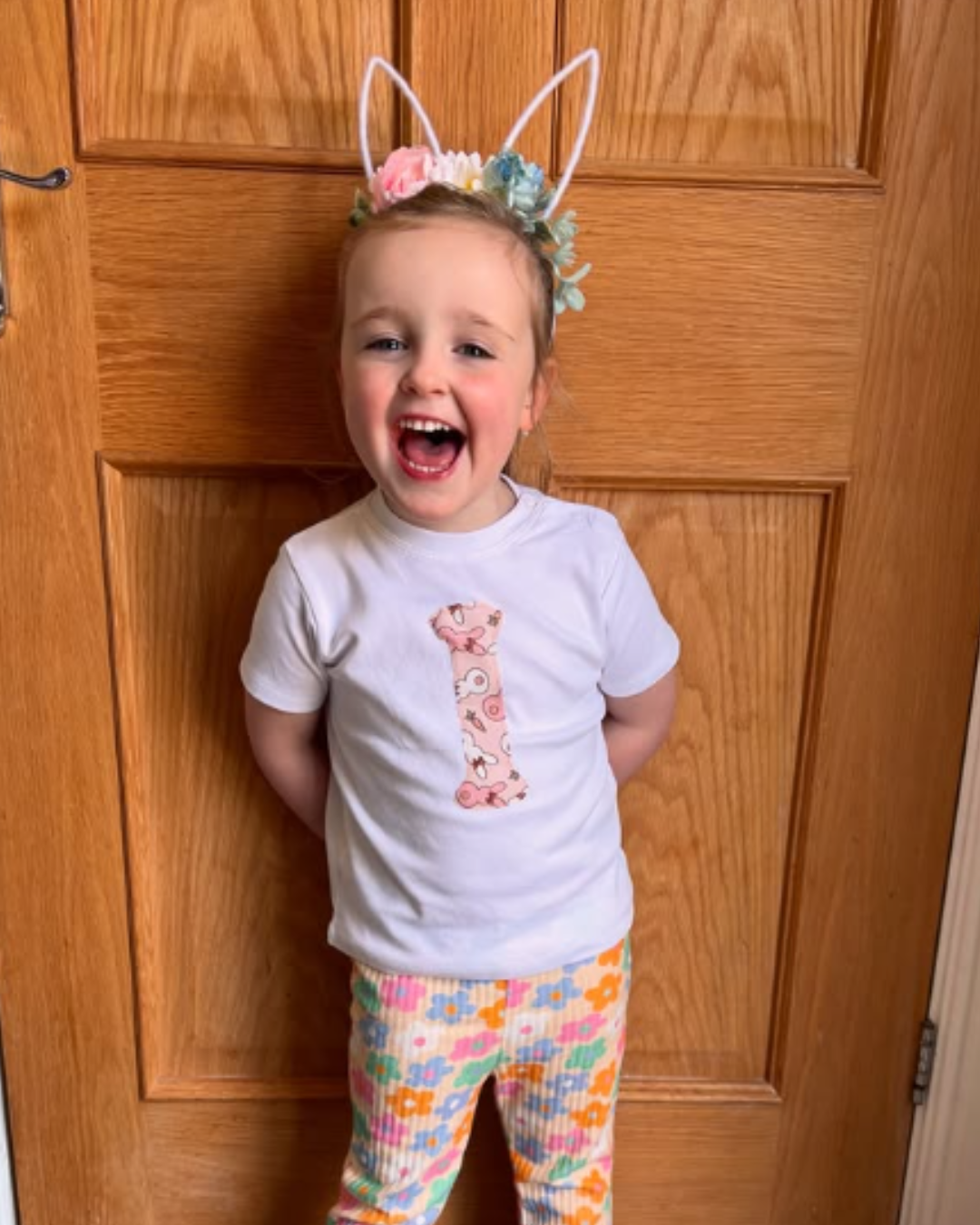 Child wearing bunny ears and a white shirt with an I appliqued on in a bunny  design.